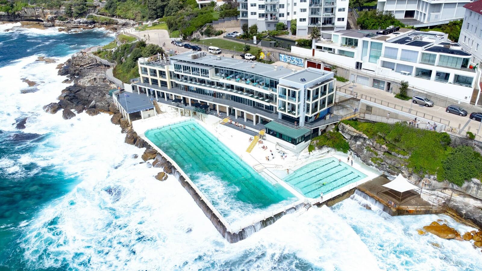 Aerial view of the Bondi Icebergs ocean pool with waves breaking over the rock wall