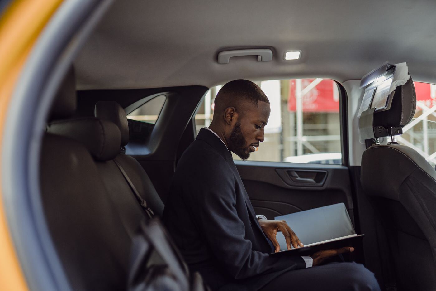 Business passenger reading a tablet in the rear seat