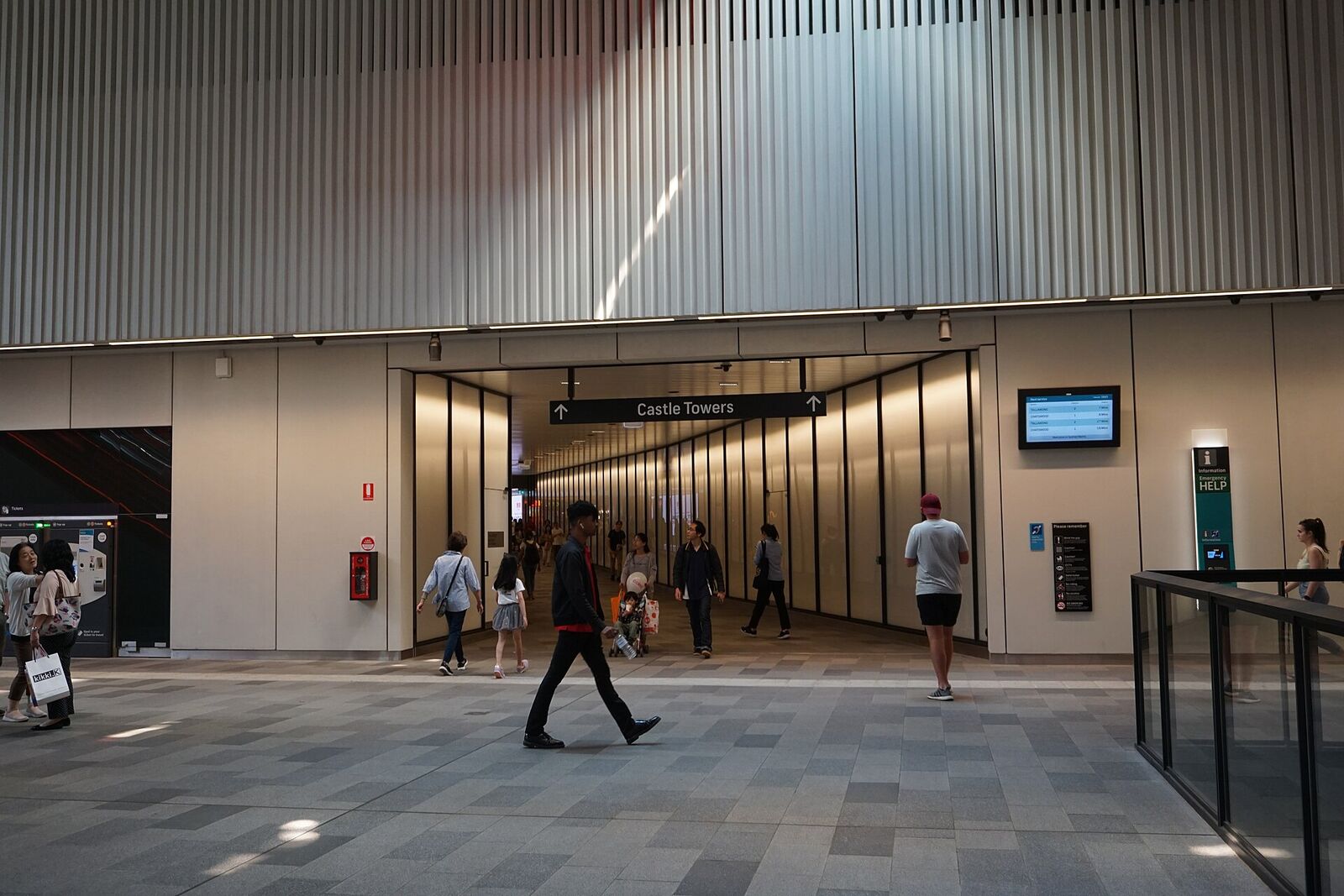 Passengers walking through the Castle Hill Metro concourse towards the signed Castle Towers exit tunnel