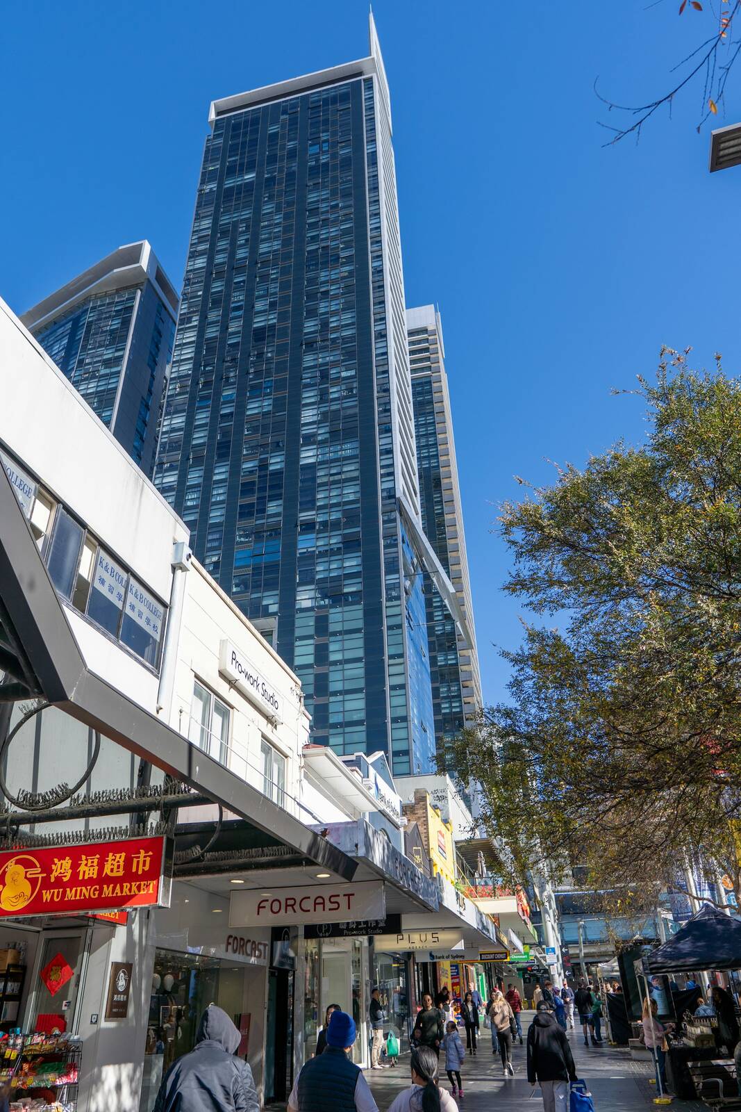 Shoppers walking along the Victoria Avenue mall in Chatswood beneath tall glass apartment towers