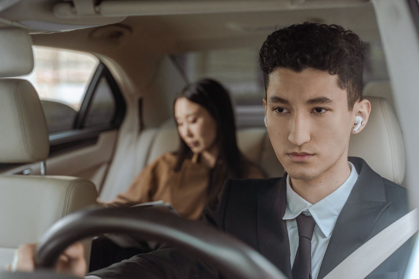 Chauffeur driving while a passenger sits in the back seat
