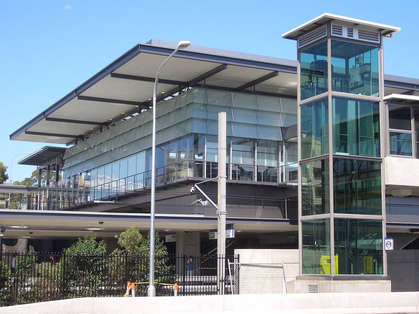 Epping railway station building with its glass lift tower and long roof against a blue sky