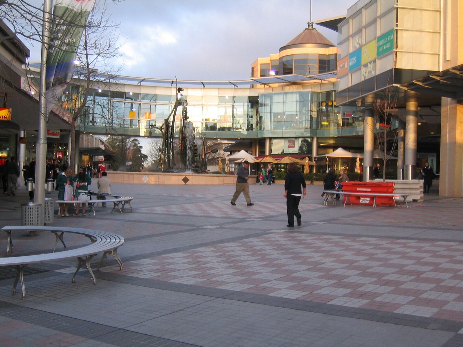 Hornsby pedestrian mall with its water clock sculpture, curved benches and the glass front of Westfield Hornsby