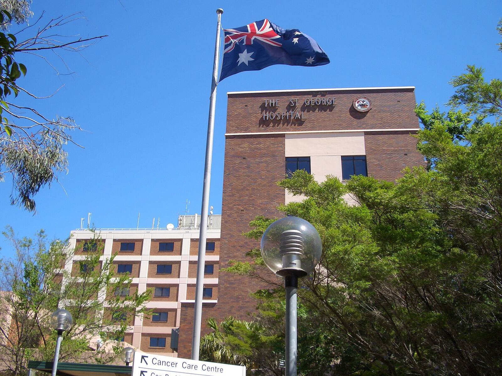 St George Hospital building in Kogarah with its name in raised letters, an Australian flag and trees in front