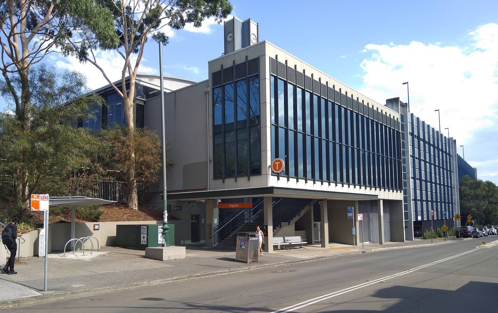 Western entrance to Kogarah railway station on Station Street, with a glass-fronted building above the stairs