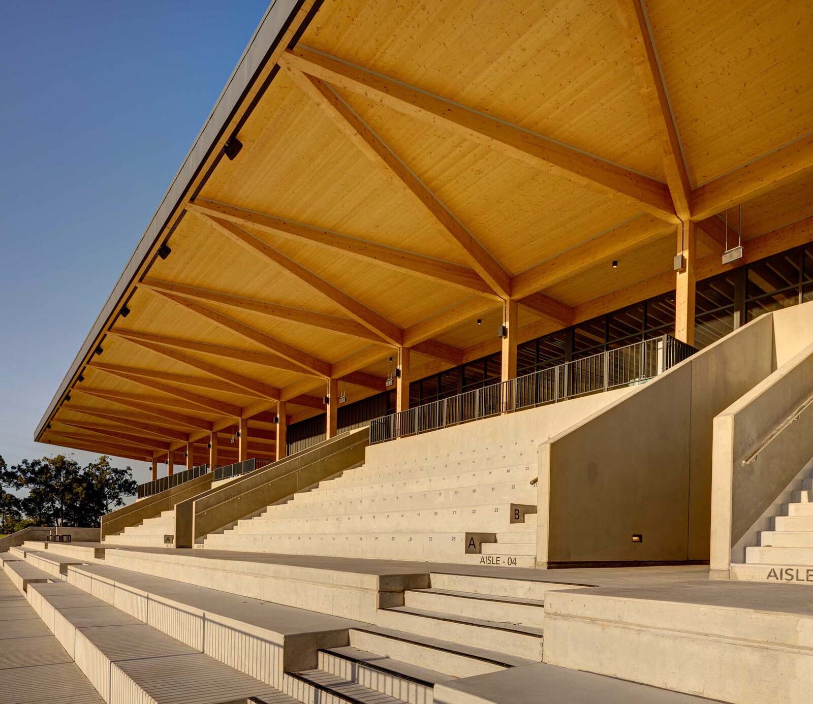 Timber roof and concrete seating of the grandstand at Eric Tweedale Stadium in Granville Park