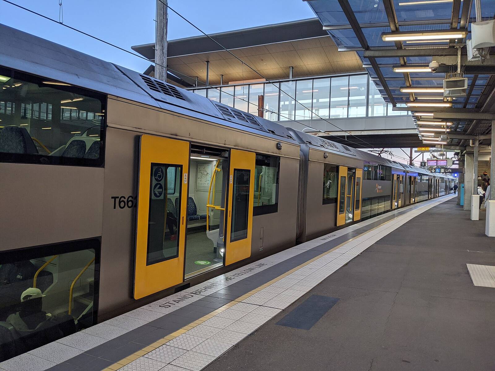 Sydney Trains double-deck train waiting at a platform under the new canopy at Penrith station