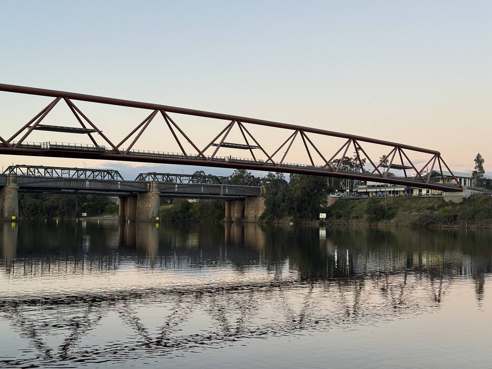 Yandhai Nepean Crossing footbridge and the Victoria Bridge reflected in the Nepean River at dusk