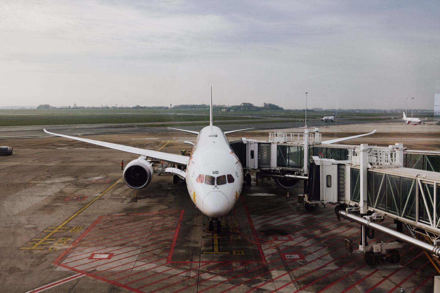 Passenger jet parked at an airport gate with an aerobridge attached