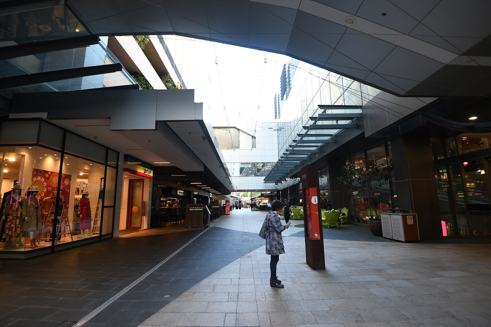 Open-air walkway lined with shopfronts under the canopy at Top Ryde City