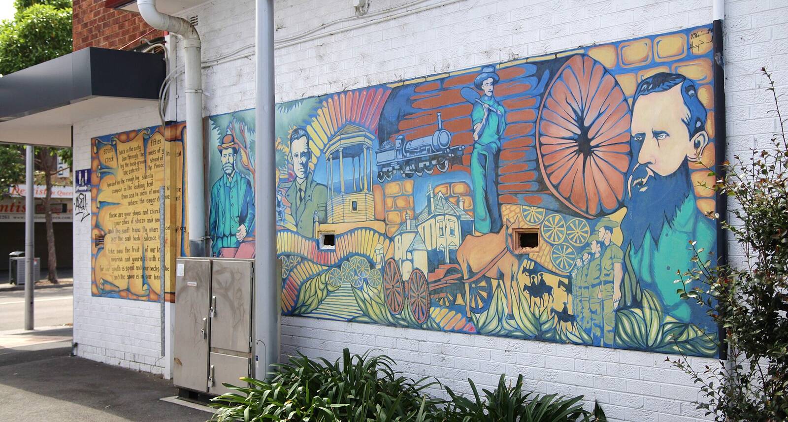 Colourful historical mural on a Queen Street wall in St Marys showing a steam train, horse-drawn wagon and local figures