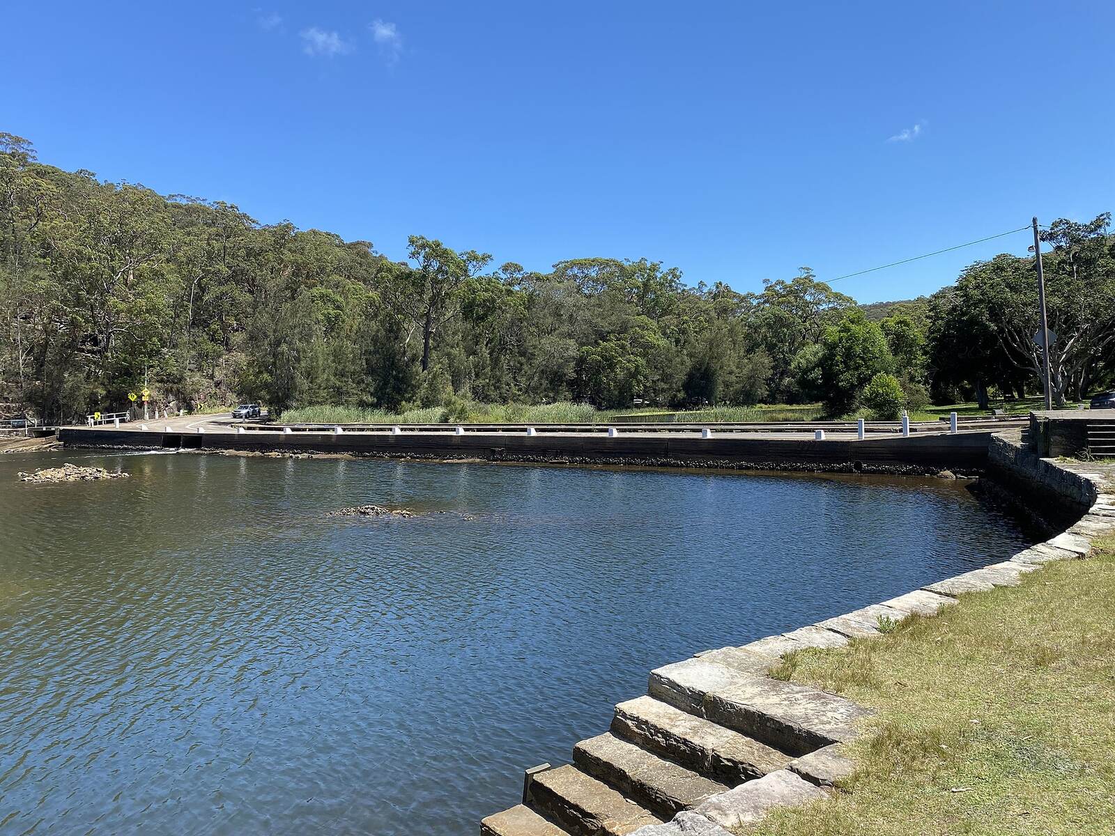 Audley Weir causeway crossing the Hacking River, with sandstone steps and bushland in Royal National Park