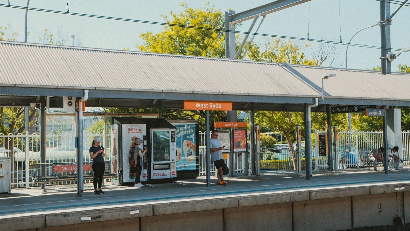 Passengers waiting under the platform awning at West Ryde railway station