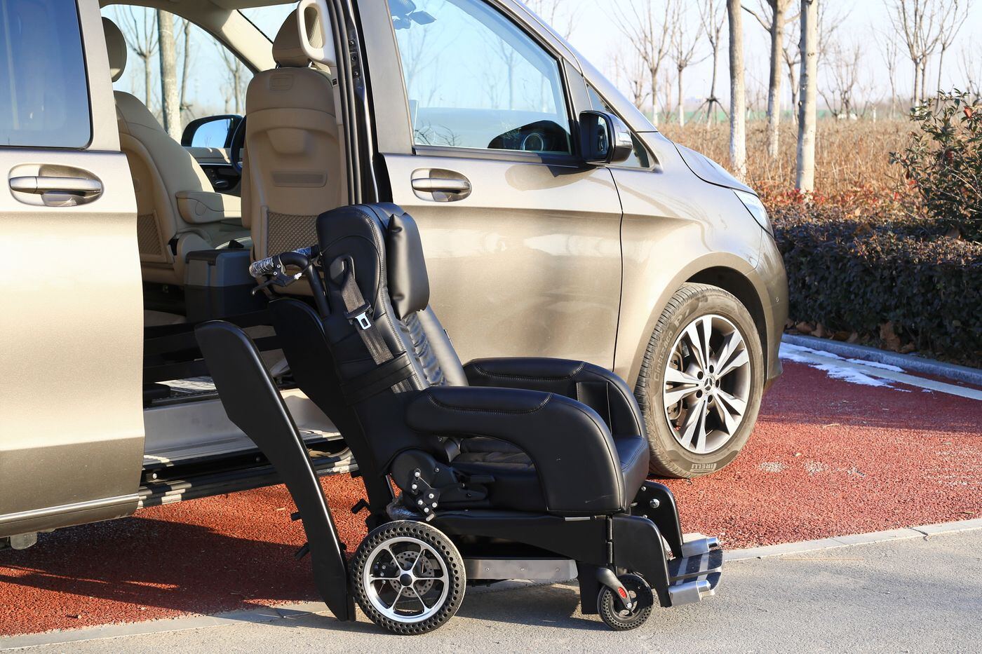Open sliding door of a van with a wheelchair beside the seat